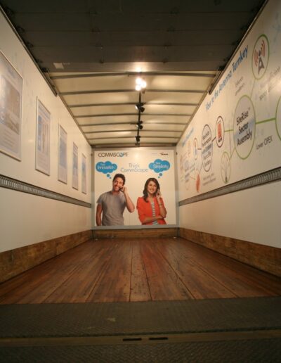 Empty truck interior featuring wooden flooring and marketing graphics on the walls.