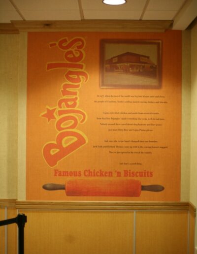 Bojangles' wall mural features bright orange background, logo, and tagline promoting chicken and biscuits.